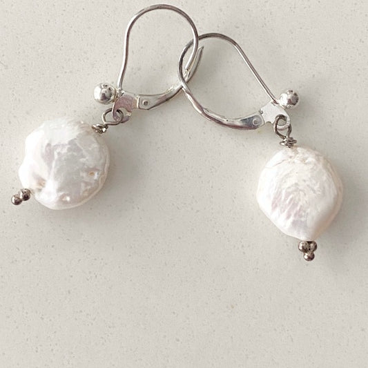 Overhead image of white coin pearl earrings on sterling silver fancy lever-back ear wires