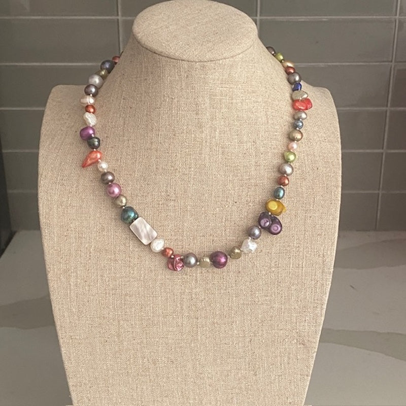 Front view 17-inch multi-coloured pearl necklace on linen jewelry display 