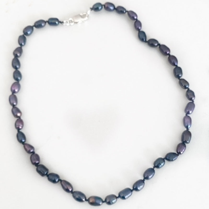 Top view of the black pearl hand-knotted 18-inch necklace with sterling clasp.