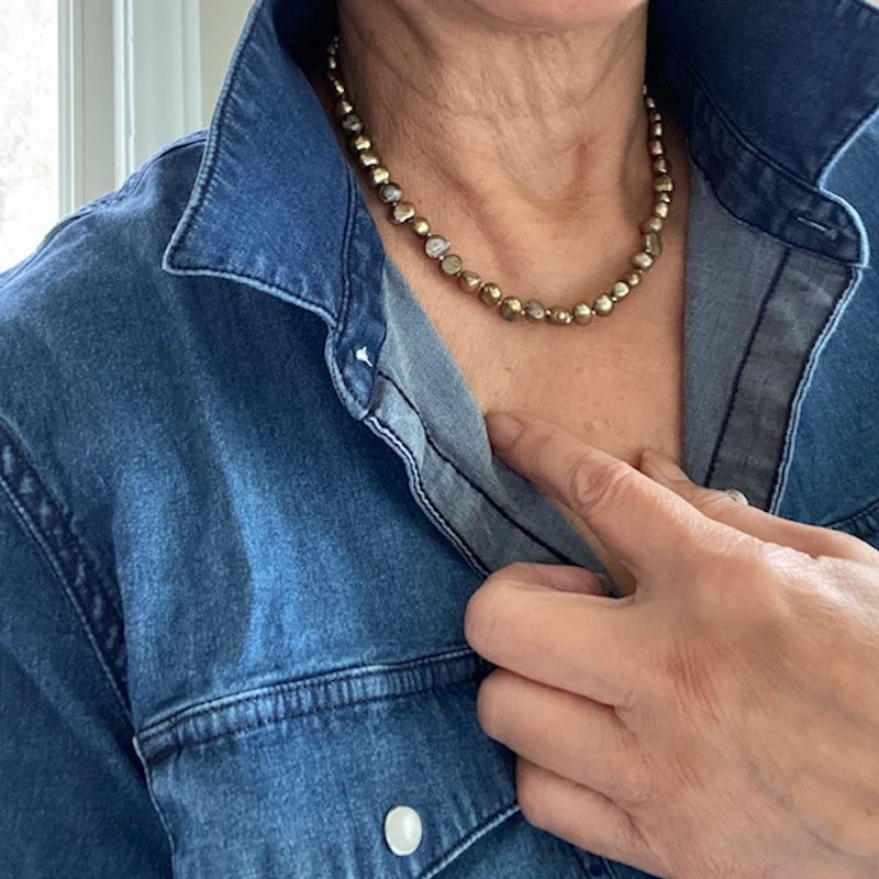 Closeup of model wearing the 16-inch bronze pearl knotted choker and casual blue denim shirt