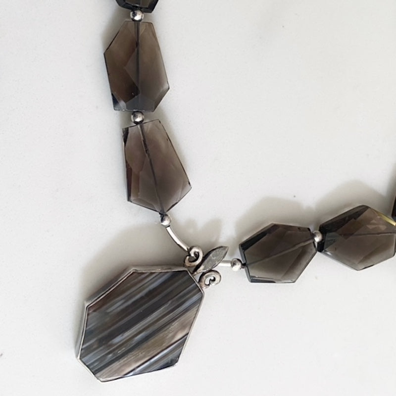 Closeup view of the flat faceted Smoky Quartz beads and centre Banded Agate pendant on its sterling tube