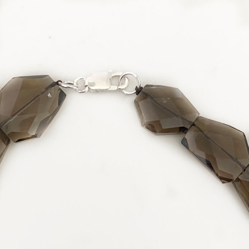 Closeup view of the sterling silver lobster clasp of the Smoky Quartz Banded Agate Kinetic Motion necklace