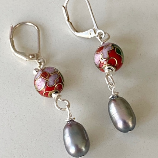 Closeup of the round red cloisonne bead 1-inch dangling earrings with large oval grey potato pearl accent on stainless steel lever-backs