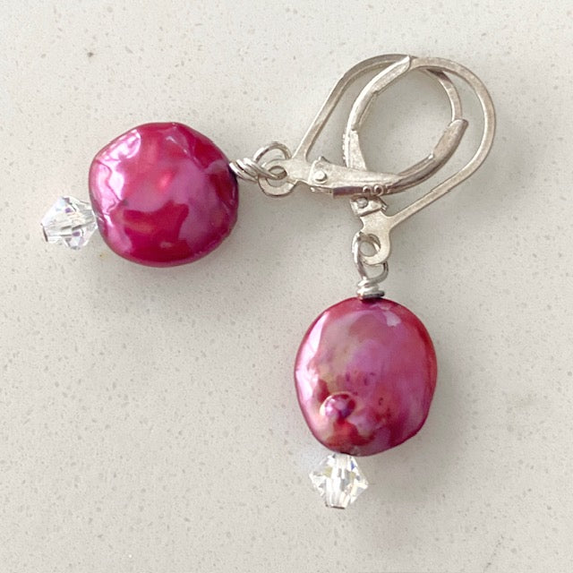Sterling silver lever-back earrings showcase dyed cranberry-coloured coin pearls with a sparkling clear Austrian crystal accent. Top view.