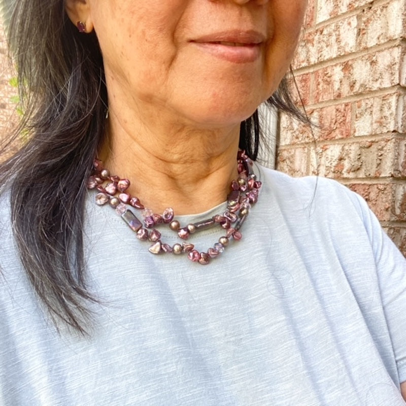 Model wearing pale blue top and the double strand knotted maroon pearl necklace