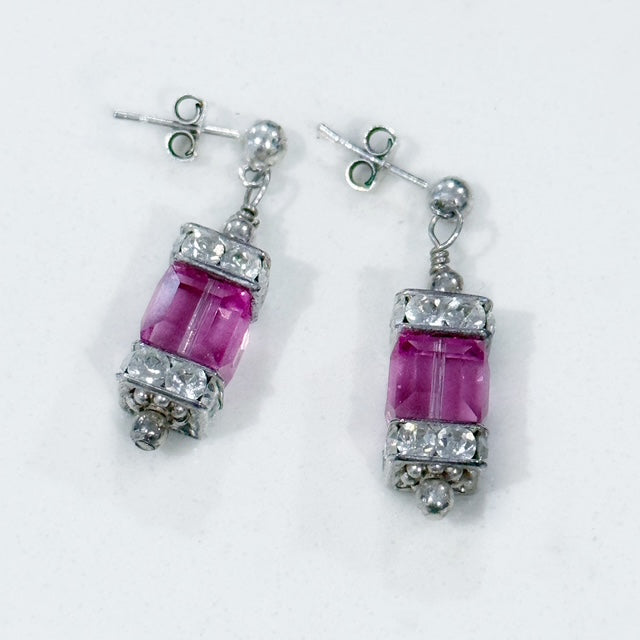 Pair of earrings with pink gemstones and silver accents on a white background