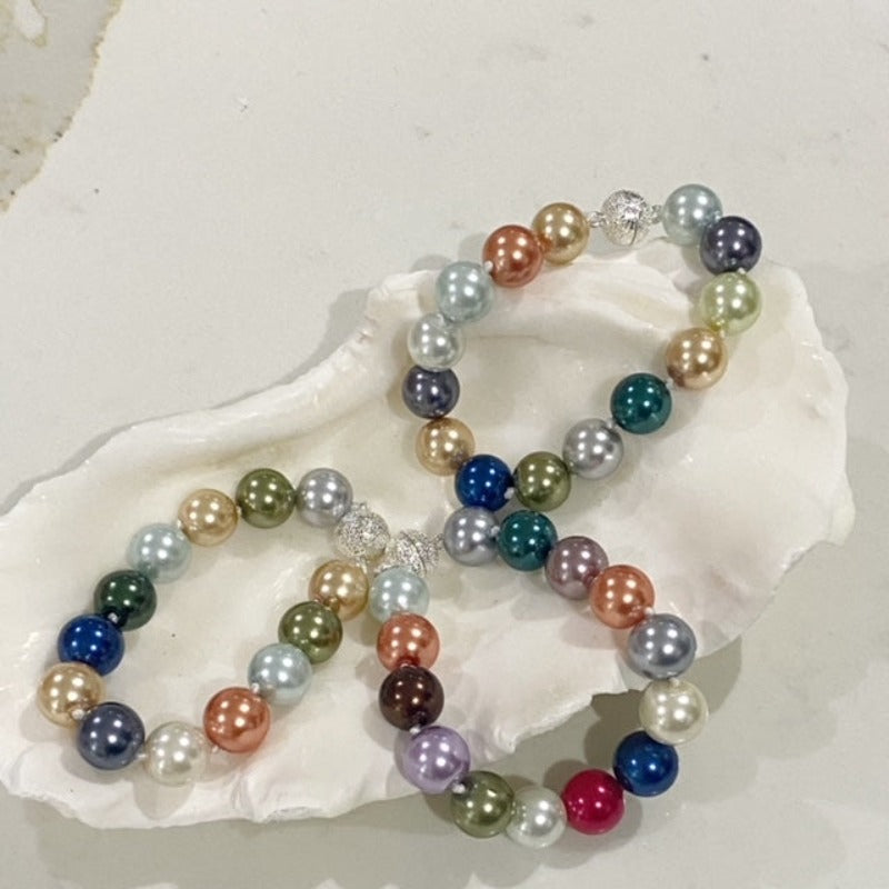 Shell containing 3 multi-coloured shell pearl bracelets