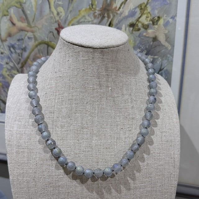 Pale blue shimmer necklace displayed on linen jewellery bust