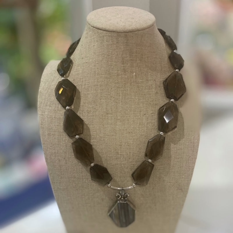 Smoky Quartz Banded Agate Kinetic Motion Necklace shown on a linen jewelry display stand