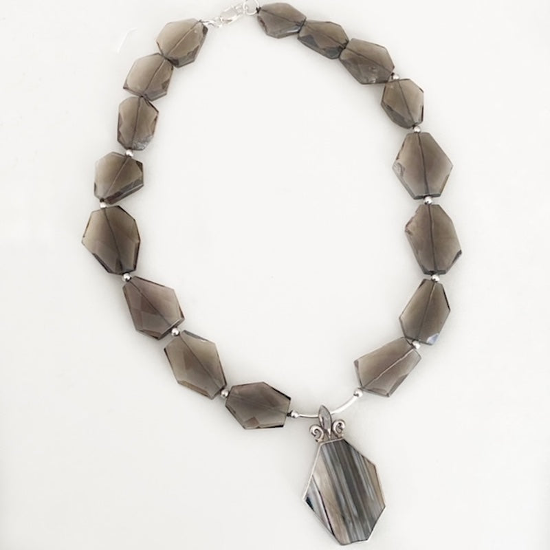 Hand-knotted Smoky Quartz faceted flat beads with a brown Banded Agate in Sterling silver that slides freely along its silver tube. Top view.