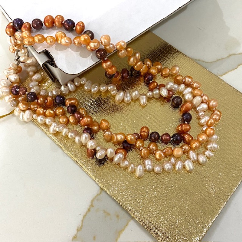 Triple strand orange brown white knotted pearl necklace shown with jewelry pouch and box used for shipping 