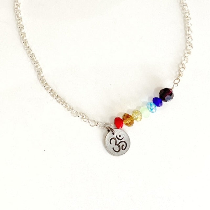 Closeup of the facetted coloured crystals representing the Chakras and the metal Ohm Charm