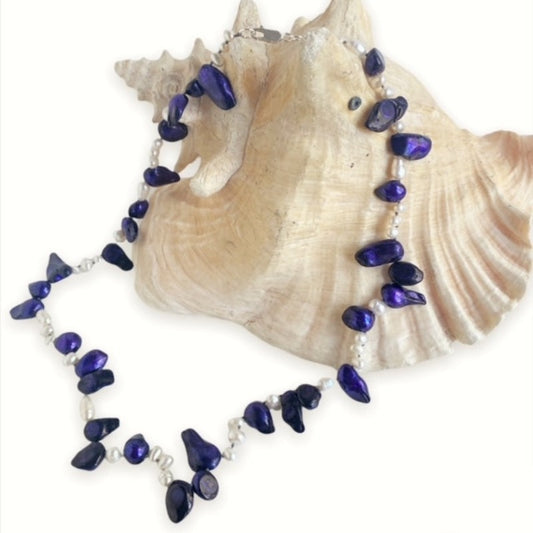 Blue-purple and white pearl necklace 22 inches hand-knotted with sterling clasp shown on display conch shell