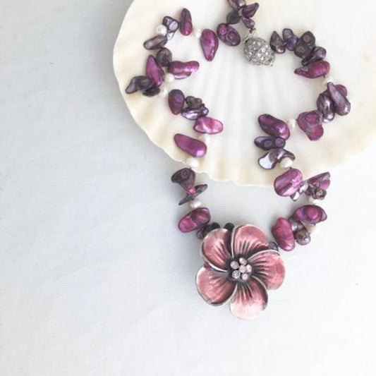 Bold Single Strand Hand-knotted Fuchsia Pearls with a big Purple Glazed Flower Accent shown Top View on a shell display