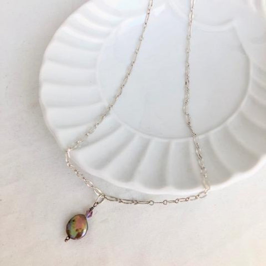 Iridescent Bronze Coin Pearl Single Drop Pendant on delicate 18" Sterling Silver chain shown on white ceramic dish