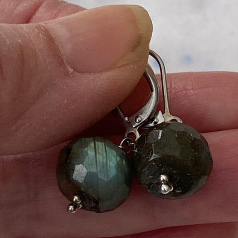 Chunky Labradorite nugget earrings held between model's thumb and fingers
