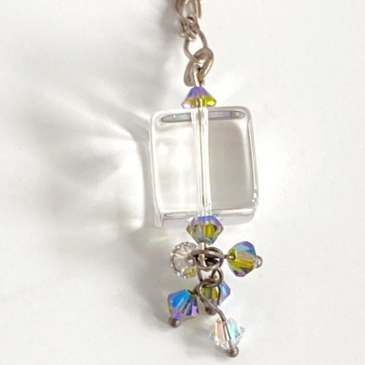 Closeup of the clear cube bead with wire-wrapped cluster of dangling blue-green and white crystal accents 