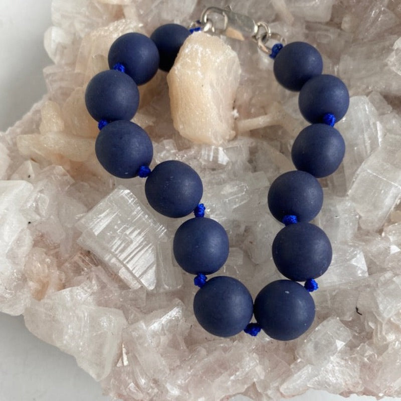 Dark navy 8-inch knotted drusy power statement bracelet shown on crystal prop