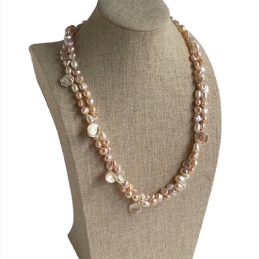 Double strand pink pearl 22-inch knotted necklace shown 3/4 view on a linen jewelry display stand