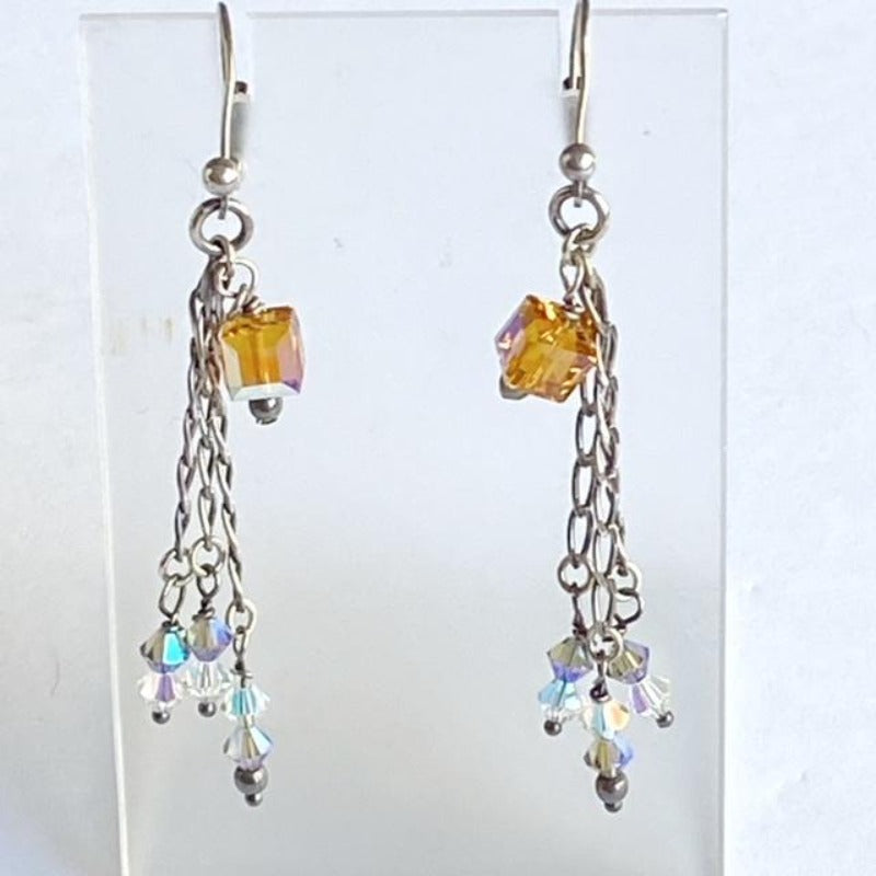 Yellow topaz-coloured crystal cube and triple sterling chain earrings on leverbacks shown suspended on earring display