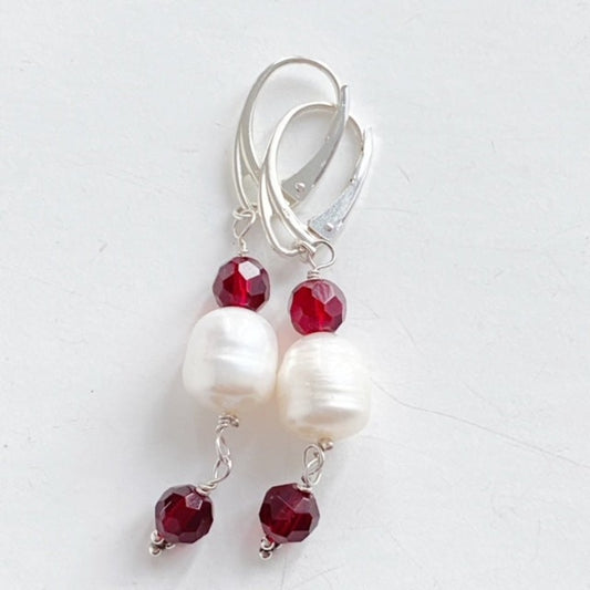 Red garnet and white pearl dangling earrings on modern silver lever-back ear wires top view