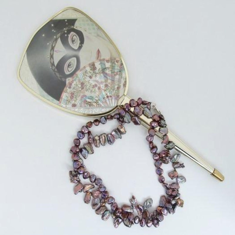 Maroon Double Strand Hand-knotted Keshi Pearl Necklace beside hand mirror prop