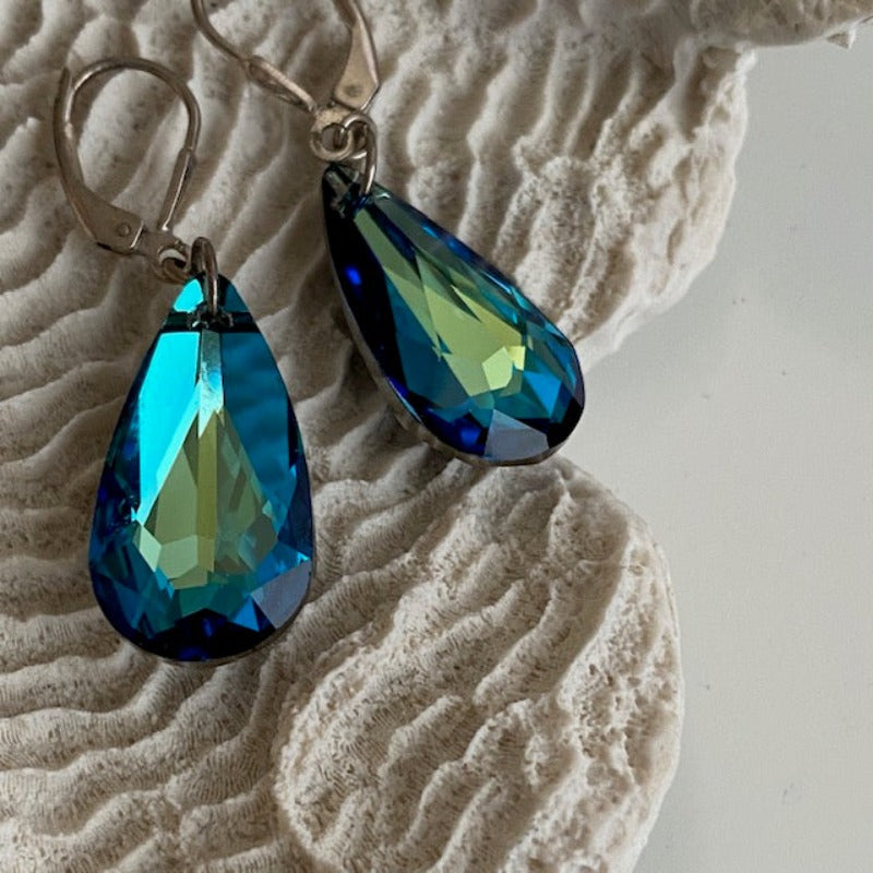 Long blue dangling facetted Crystal pear-shaped Sterling leverback earrings shown on prop