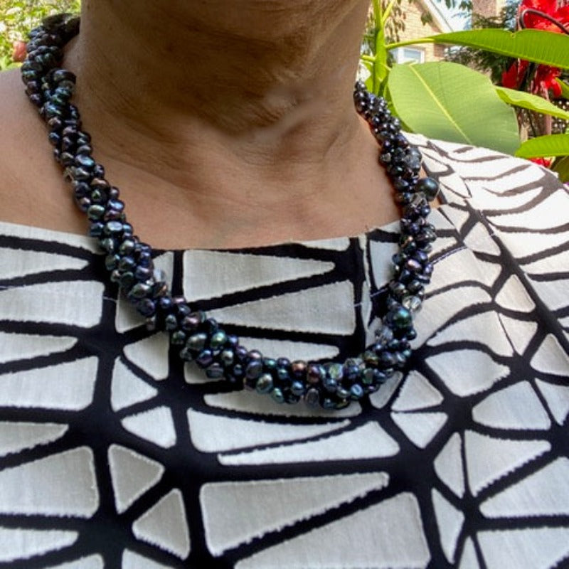 Model wearing the long 47-inch knotted black pearl and crystal necklace twisted  into a longer chunky styles