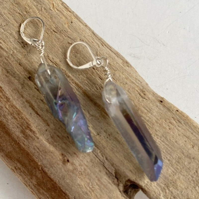 Long lavender crystal spike statement earrings shown on driftwood