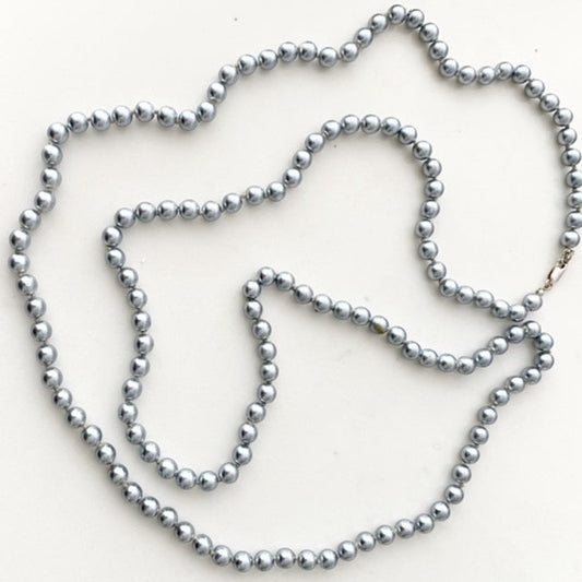 Long 46-inch knotted medium gray glass pearl necklace with  small sterling silver clasp top view