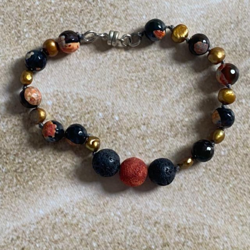 Orange Black Agate Lava Rock Gold Pearl Essential Oil Bracelet Top View on sand