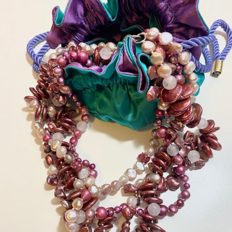 Chunky multi-strand knotted pink and rose freshwater  pearl necklace shown with a draw-string prop jewelry bag for display purposes only