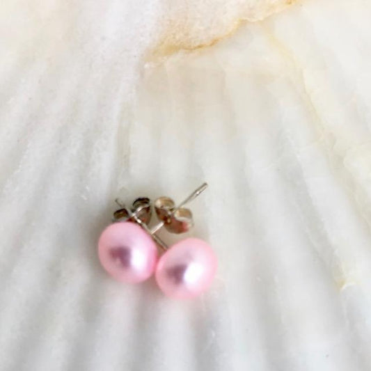 Pink Freshwater Pearl Sterling Silver Stud Earrings shown  closeup on a shell