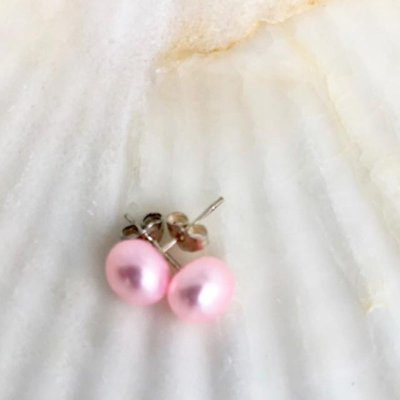Pink Freshwater Pearl Sterling Silver Stud Earrings shown  closeup on a shell