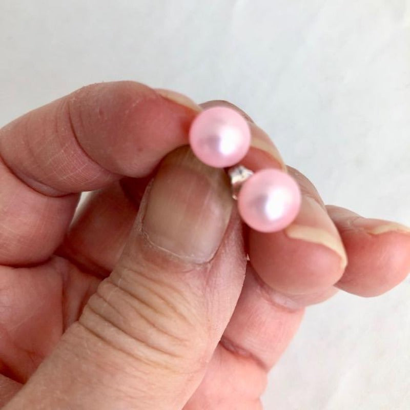 Pink Freshwater Pearl Sterling Silver Stud Earrings shown closeup being held by model 