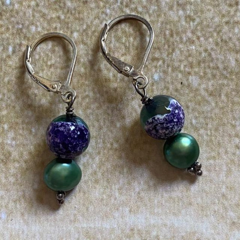 Purple Green Mottled Agate Wire-wrapped Sterling Silver Lever-back Earrings shown on sand