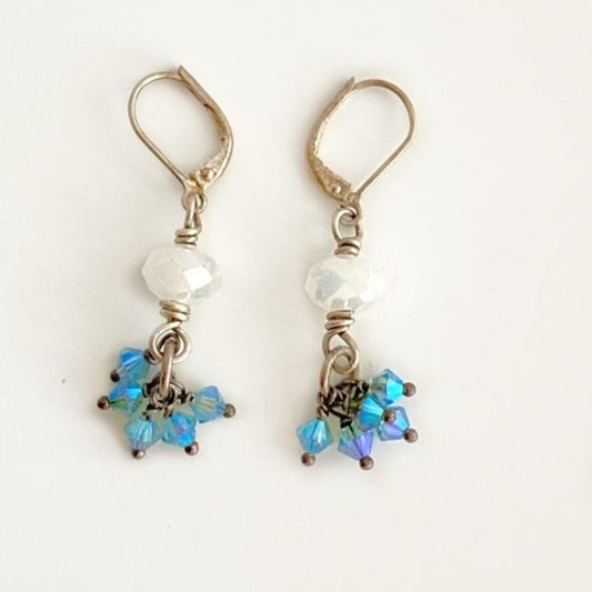 Facetted opaque white crystal and tiny blue Austrian crystals dangling in a cluster below -silverplated leverback earrings top view