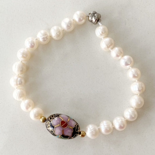 White knotted 7 1/2" freshwater pearl bracelet with oval black cloisonne bead centre accent  and button silver tone magnetic clasp top view